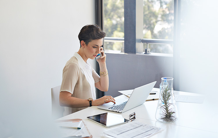 Eine Dame am Laptop und am Telefon
